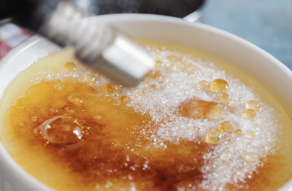 brulee torch carmelizing sugar on creme brulee
