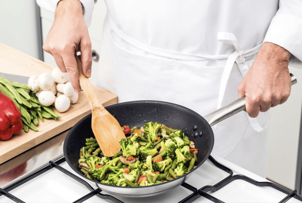 basic cooking techniques: chef sauteing vegetables in skillet