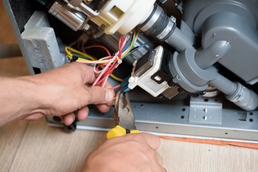 Person fixing a commercial dishwasher